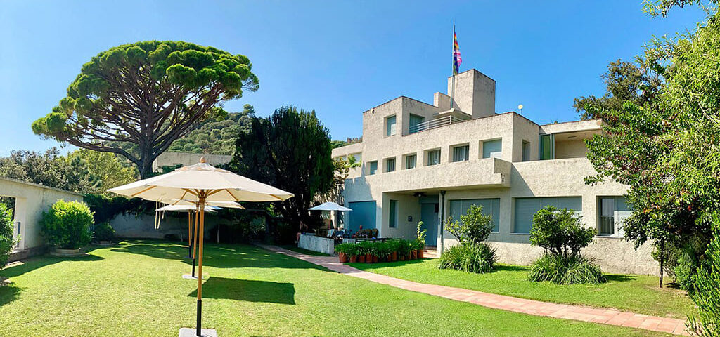 Villa moderne avec jardin et parasols.